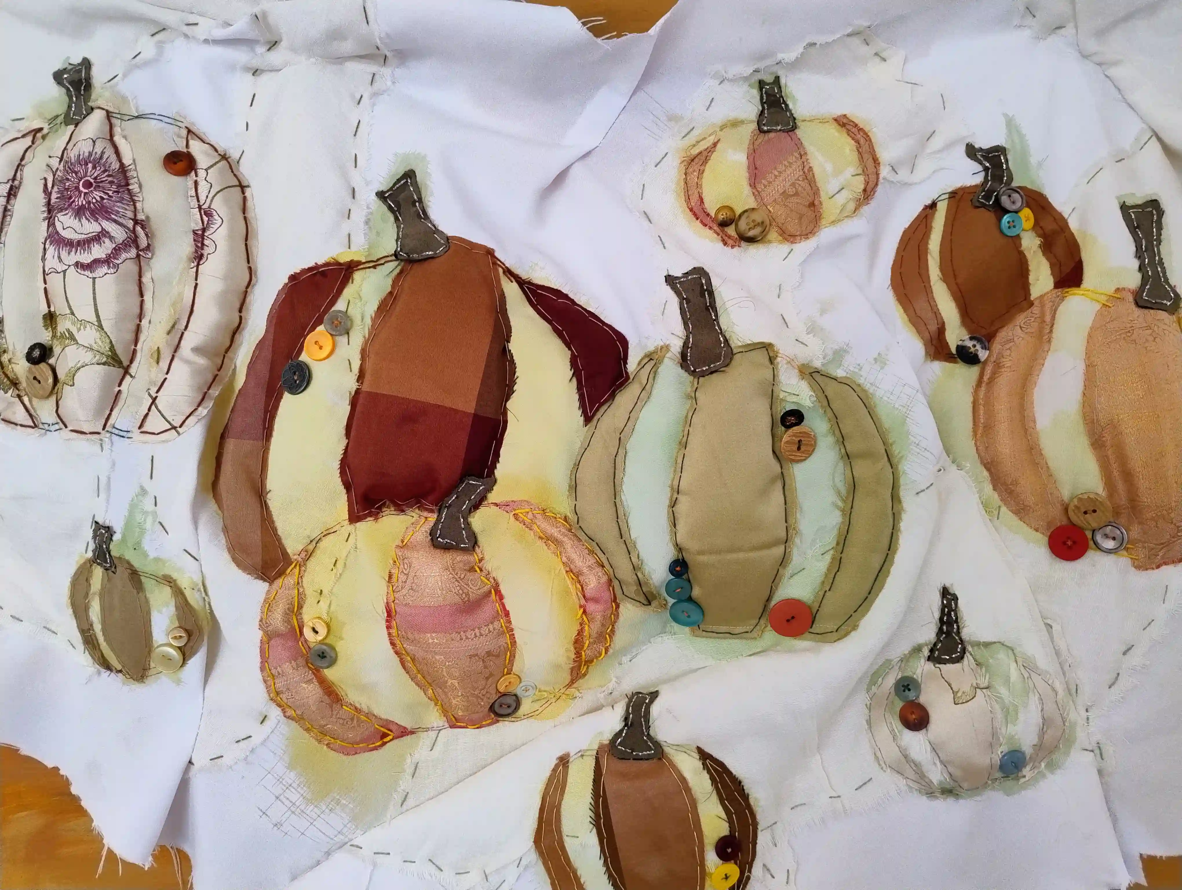 A close up of the pumpkins sewn onto white cloth